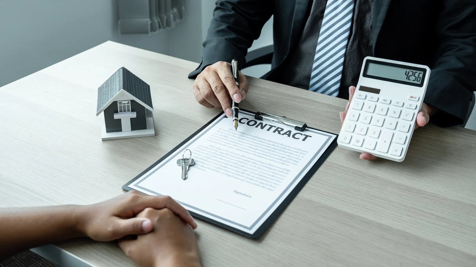 An agent reviewing a contract with clients